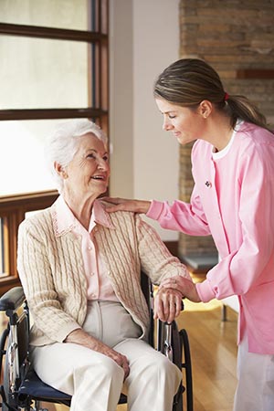 Nurse helping elderly client in wheelchair