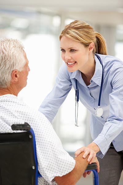 Therapist helping elderly client in wheelchair